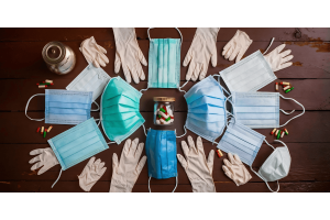 Medical gloves and masks arranged neatly on a wooden table, highlighting essential protective equipment.