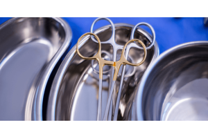 Several stainless steel bowls arranged on a surface with a pair of scissors placed on top of one bowl.