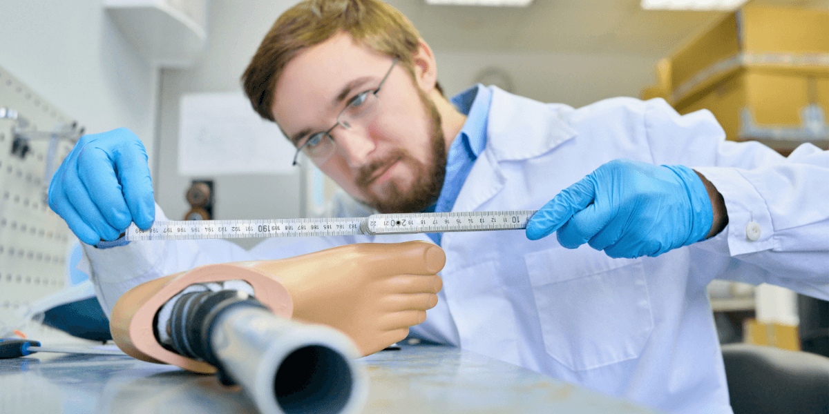 A man in a lab coat measures a foot with a ruler, focused on obtaining an accurate measurement.