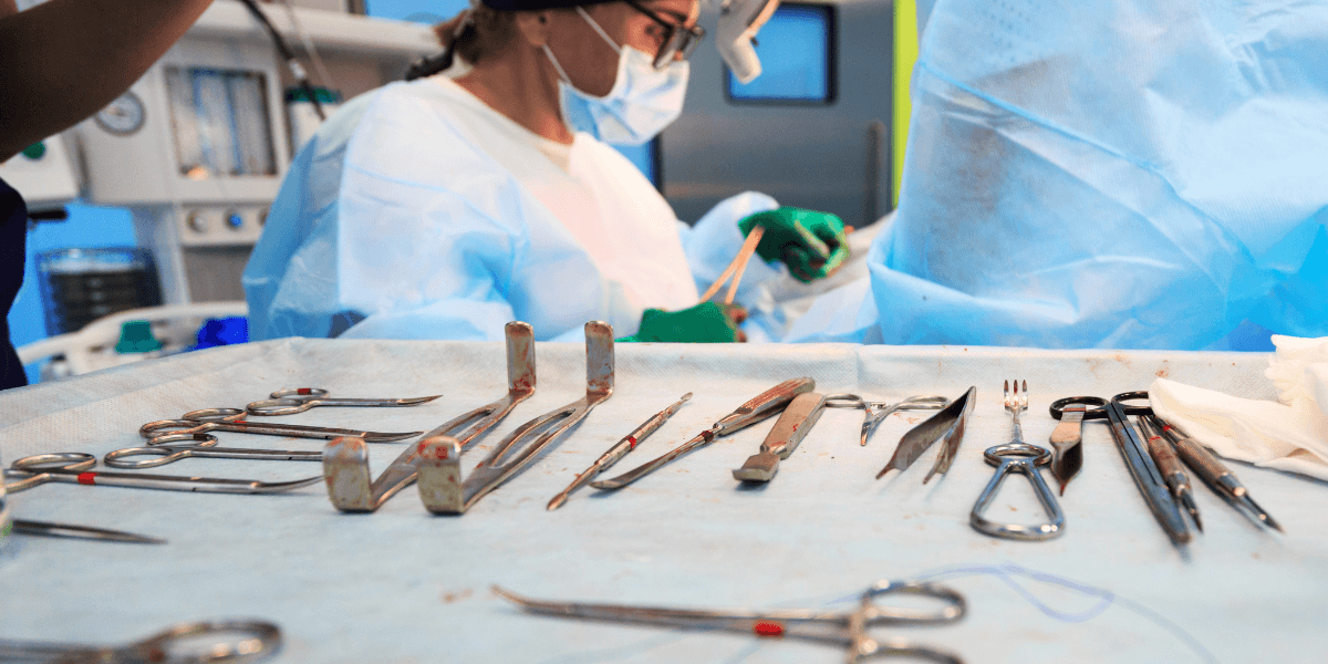 A surgeon performs an operation on a patient in a sterile operating room, surrounded by medical equipment and staff.