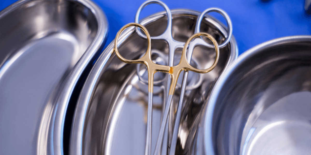 Several stainless steel bowls arranged on a surface with a pair of scissors placed on top of one bowl.